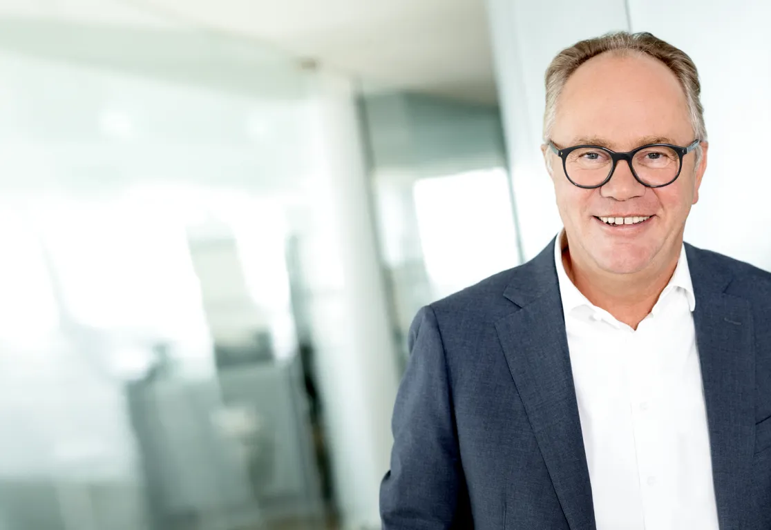 a man in a suit and glasses smiling