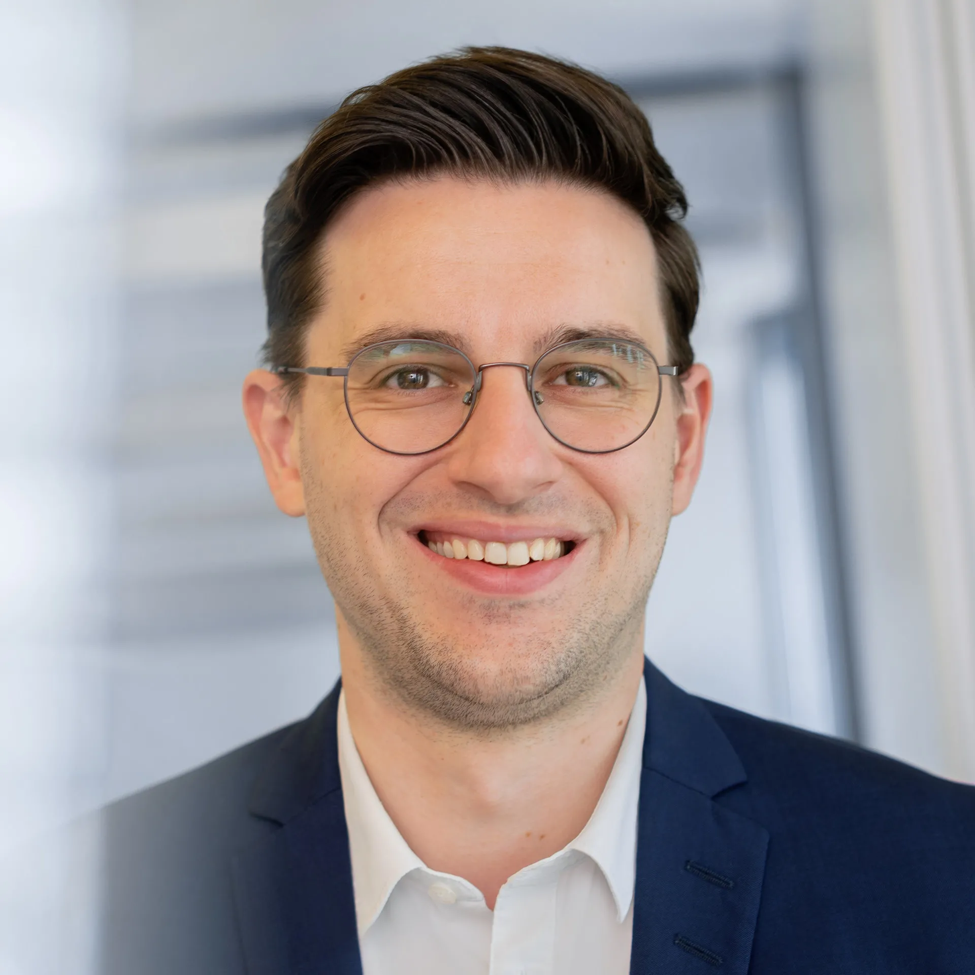 a man wearing glasses and a suit